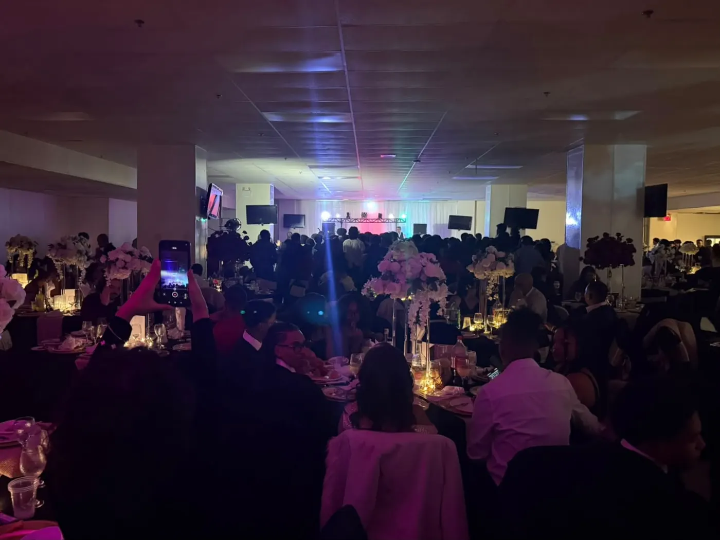 La salle de réception pendant la soirée, DJ et tables fleuries
