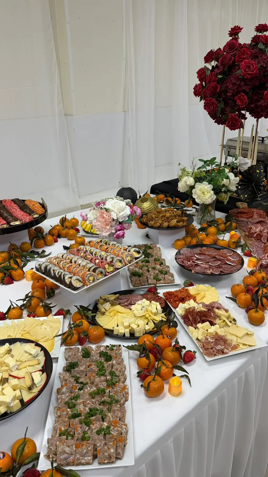 Le buffet : sushis, fromages et charcuteries entourés de mandarines et de roses rouges